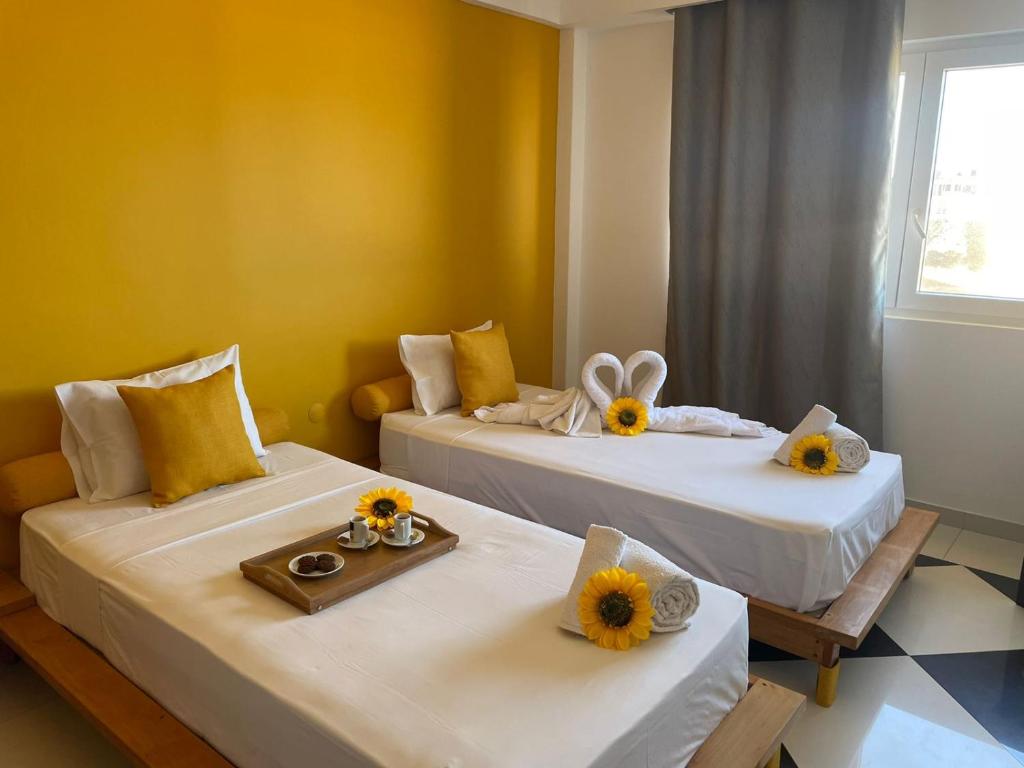 蓬塔杜索尔Residencial Sol Point Art的两张位于房间的床,上面有太阳花