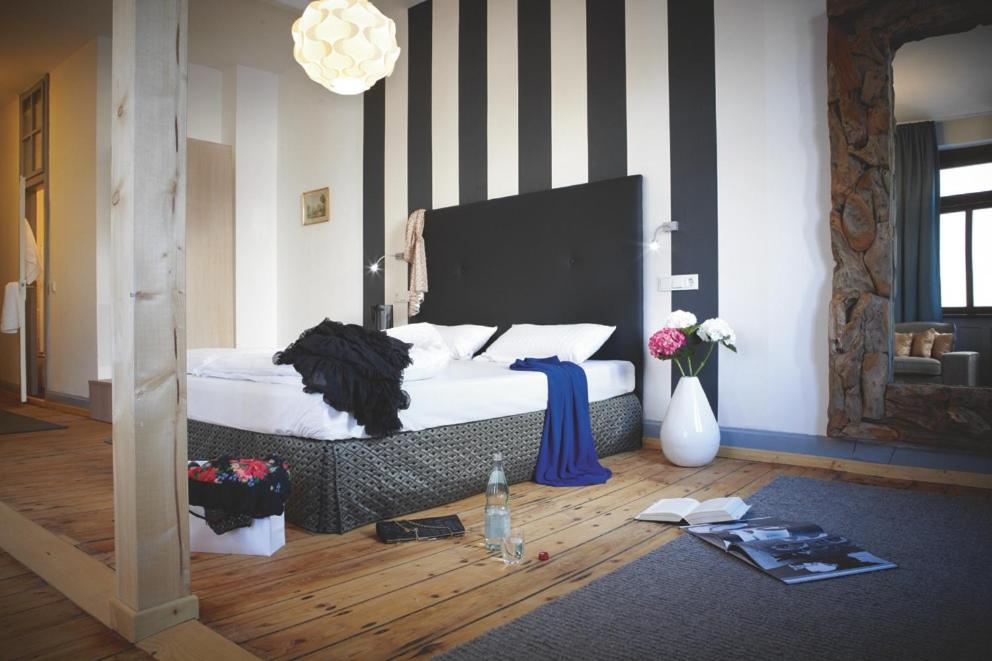 海德堡唐怀瑟酒店的一间卧室配有一张带黑白条纹墙的床