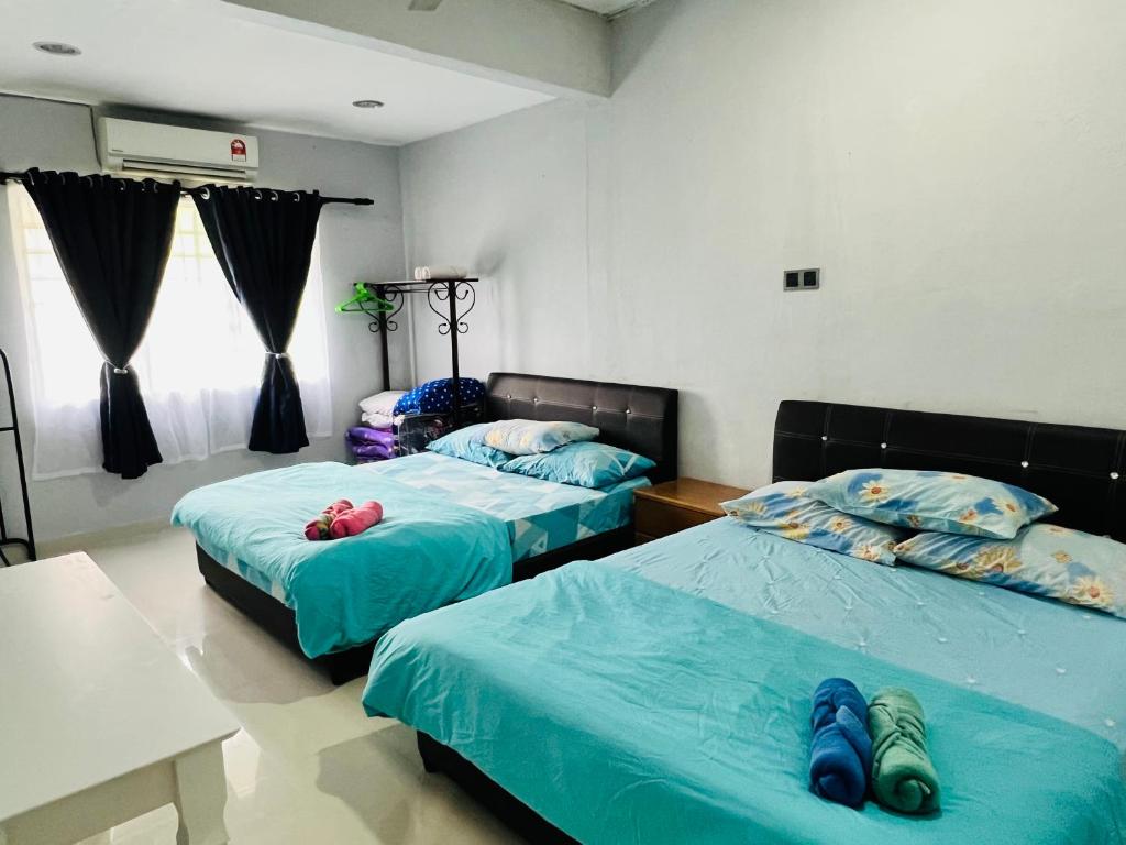 加央Sehijau Homestay Kangar的配有蓝色床单的客房内的两张床