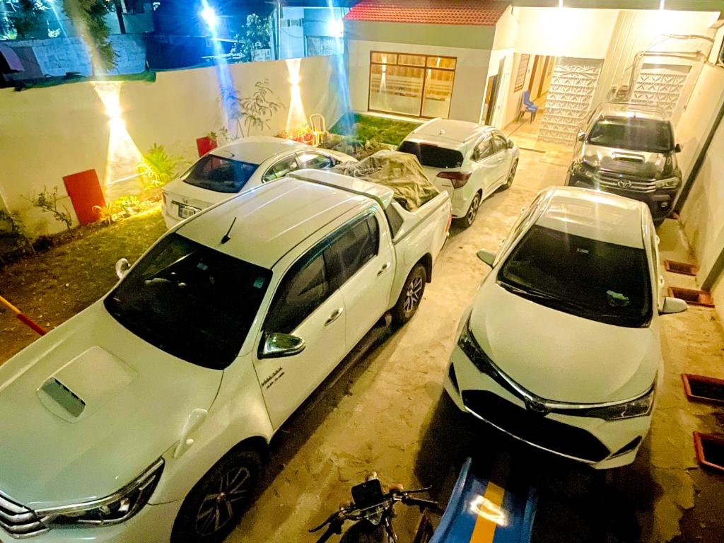卡拉奇Airport Hotel Bed & Rest的两辆白色汽车停在车库