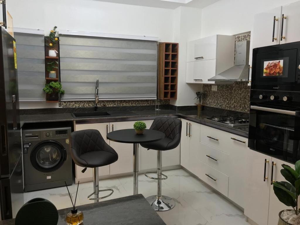KwedonuPel apartment的厨房配有两张凳子和一张桌子