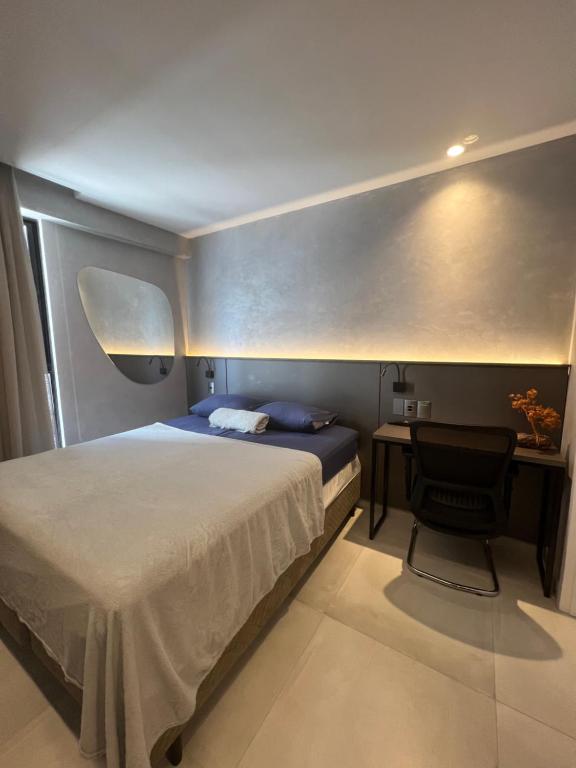 卡贝德卢FLAT aconchegante e moderno, 100m do mar的一间卧室配有一张床和一张桌子及椅子