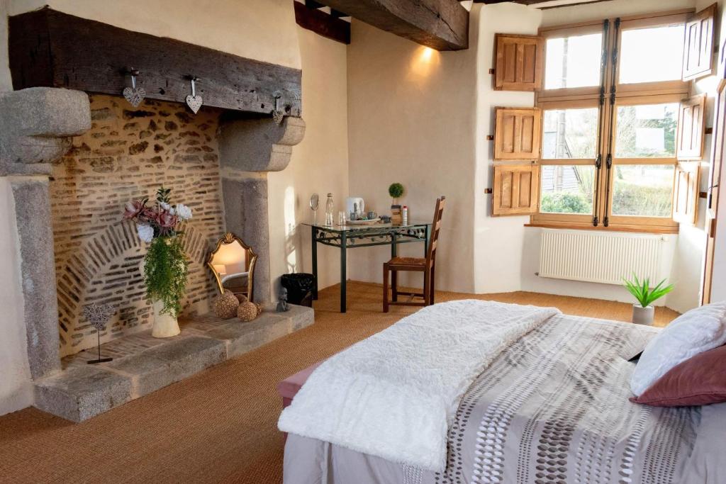 ChangéManoir de la coudre的一间带壁炉的卧室和一张位于客房内的床