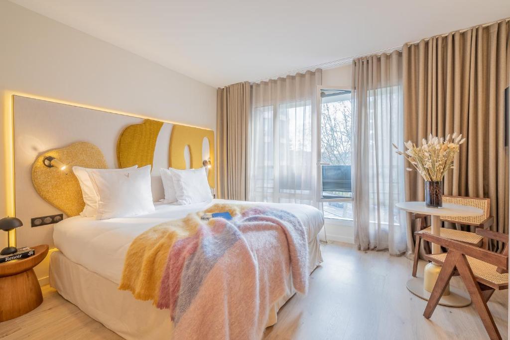 巴黎Yuna Porte-Maillot - ApartHotel的一间卧室设有一张大床和大窗户