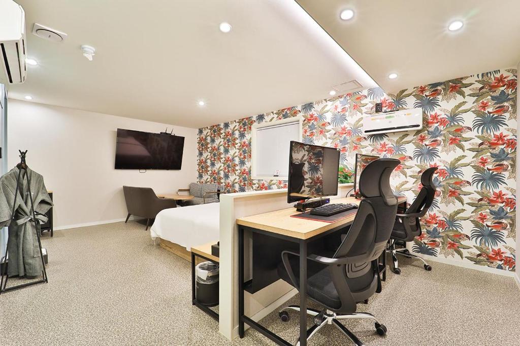 首尔吉姆斯汤姆吉酒店的一间卧室配有一张床和一张带电脑的书桌