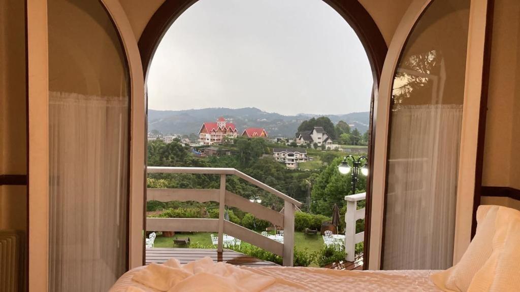 坎波斯杜若尔当Hotel Pousada Bella Locanda的一间卧室设有开放式窗户和一张床,享有美景