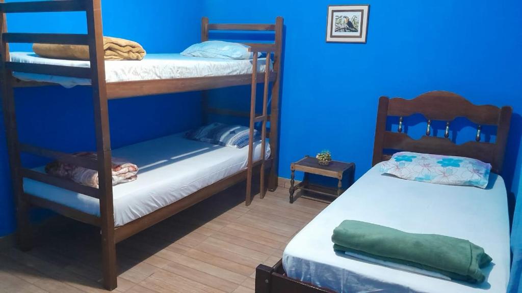 伊塔蒙蒂Casa e camping Reinaldo e Julia recanto das árvores的客房设有两张双层床和蓝色的墙壁。