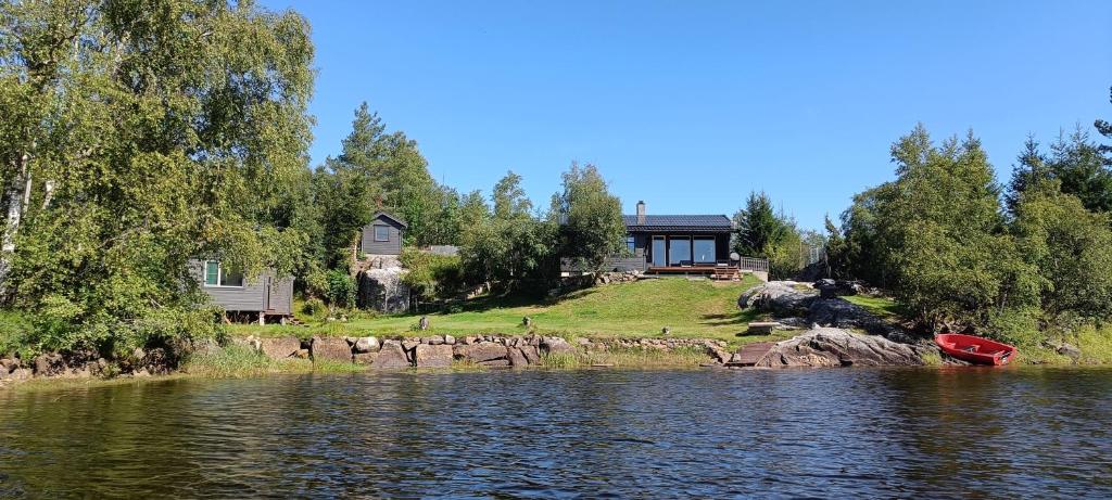 灵达尔Gauvik - Lyngdal的湖畔的房屋,有船