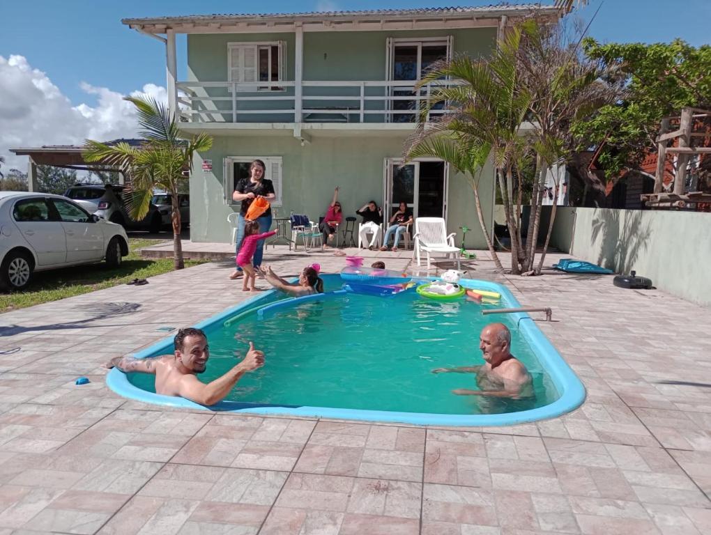 帕苏迪托雷斯Casa Praia Ribeiro SC的两个男人在游泳池玩耍