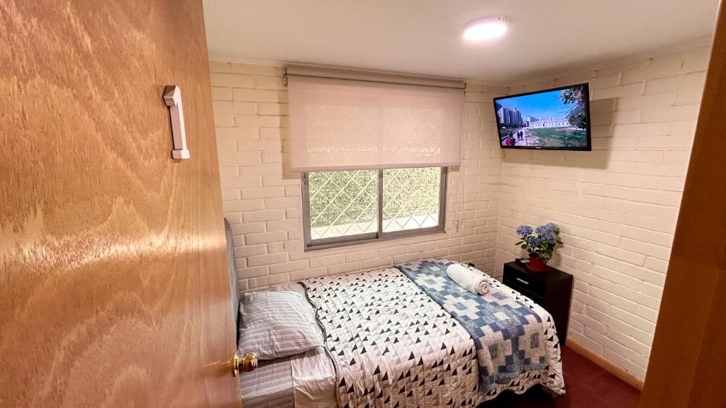 圣地亚哥Chez Humbert的一间小卧室,配有一张床和电视