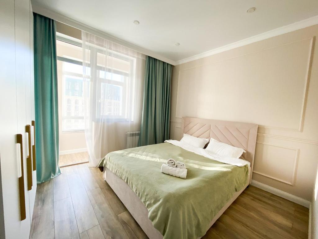 阿斯塔纳Highvill Ishim 412的一间卧室设有一张床和一个大窗户
