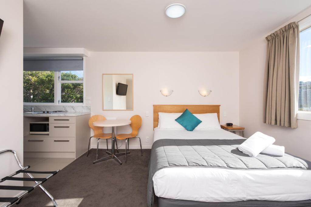 惠灵顿首都景观汽车旅馆的酒店客房带一张床、一张桌子和椅子