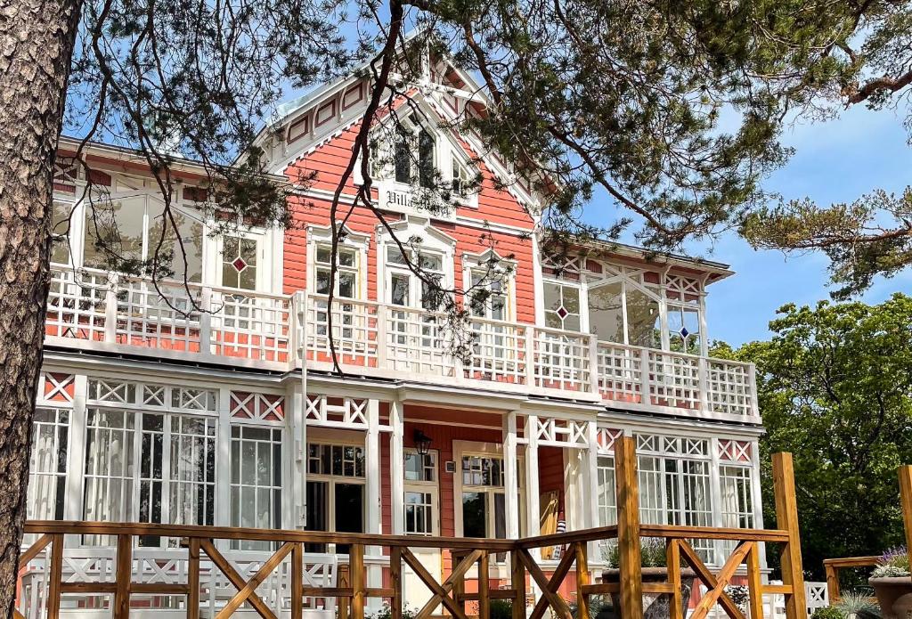 汉科Villa Maija 3 Westside的红色和白色的房子,设有白色阳台
