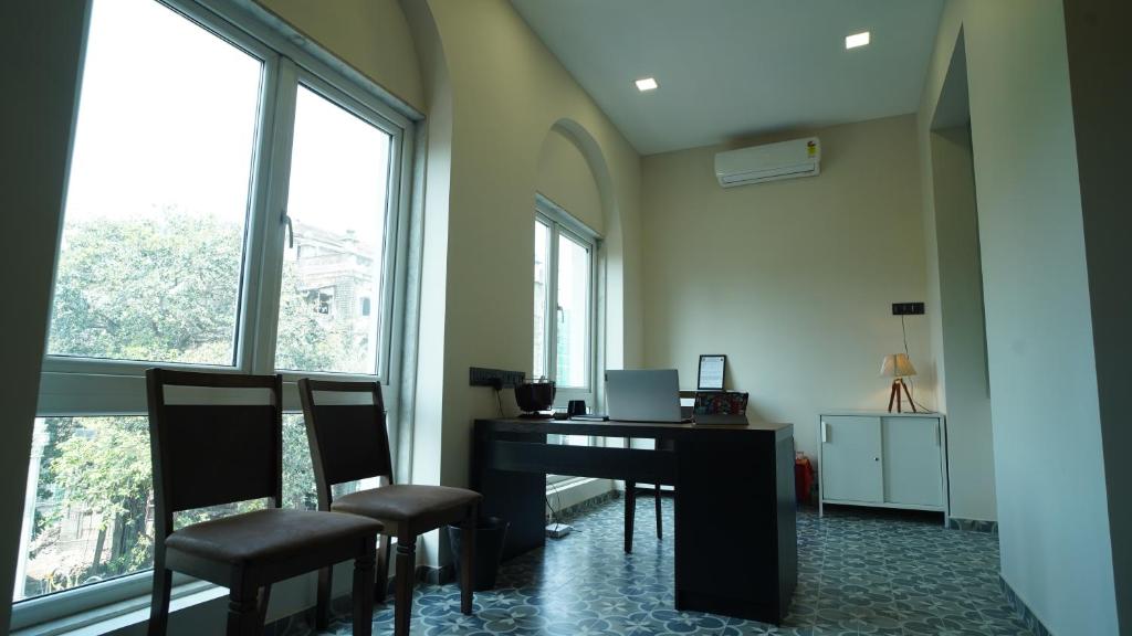孟买The Colaba Pod的办公室设有桌子、椅子和窗户