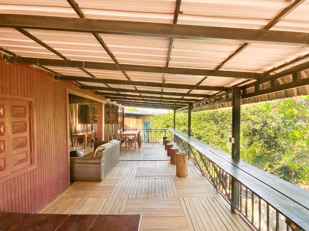 邦隆Backpacker Hostel and Jungle Trekking的房屋内带顶棚、沙发和椅子的甲板