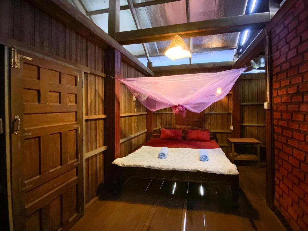 邦隆Backpacker Hostel and Jungle Trekking的客房配有带蚊帐的床。