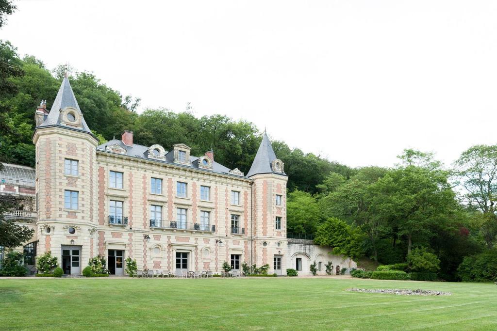 阿姆博斯Château de Perreux, The Originals Collection的一座古老的城堡,前面有草地