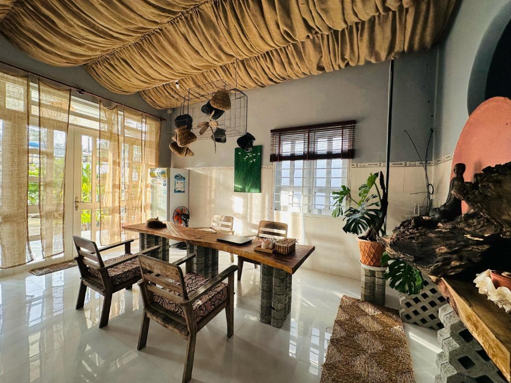 昆岛Chang's Hideaway homestay ConDao的一间带木桌和椅子的用餐室