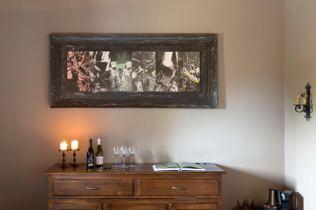 林瓜格洛萨Casa Arrigo的梳妆台上方的画,带两根蜡烛和酒杯