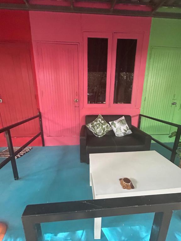 帕干岛Simple Garden Resort的客厅设有粉红色和绿色的墙壁和沙发