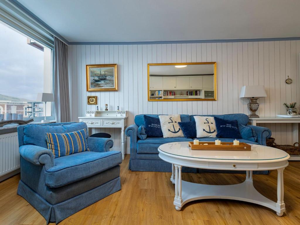 韦斯特兰Appartement Strandnah的客厅配有蓝色的沙发和桌子