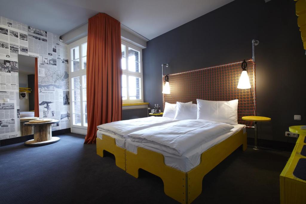 汉堡Superbude Hamburg St Pauli的卧室配有一张带白色床单和枕头的大床。