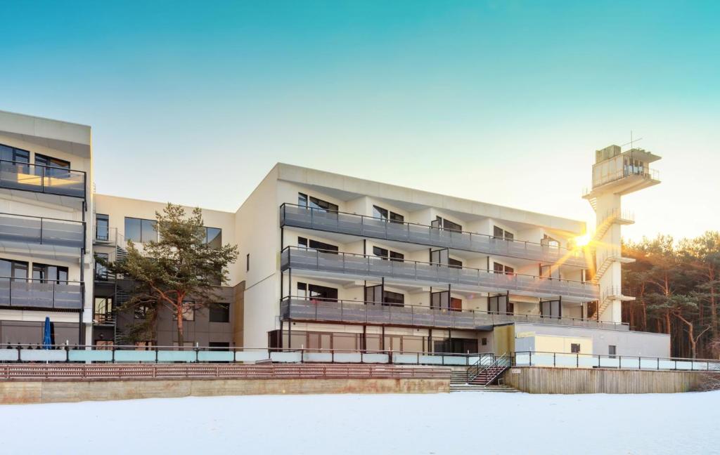 塔林Pirita Sea View Apartments One bedroom的雪地中带控制塔的公寓楼