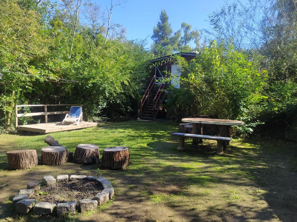 蒂格雷Cabaña enero soleado的草地上设有长凳和原木的公园