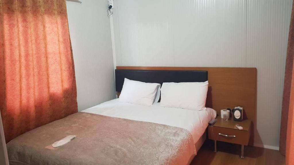 哈塔伊GÜN IŞIĞI KONAKLAMA的一间卧室配有一张带木制床头板的床