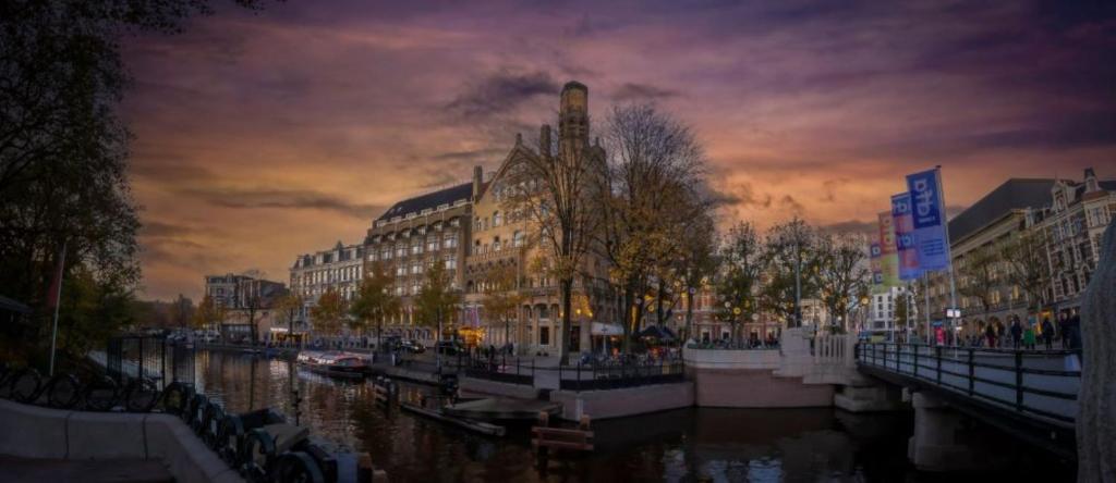 阿姆斯特丹Clayton Hotel Amsterdam American的享有拥有建筑和河流的城市美景