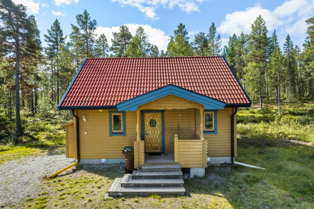 菲奈斯达伦Stuga i Funäsdalen的树林中的一个红色屋顶的小小屋