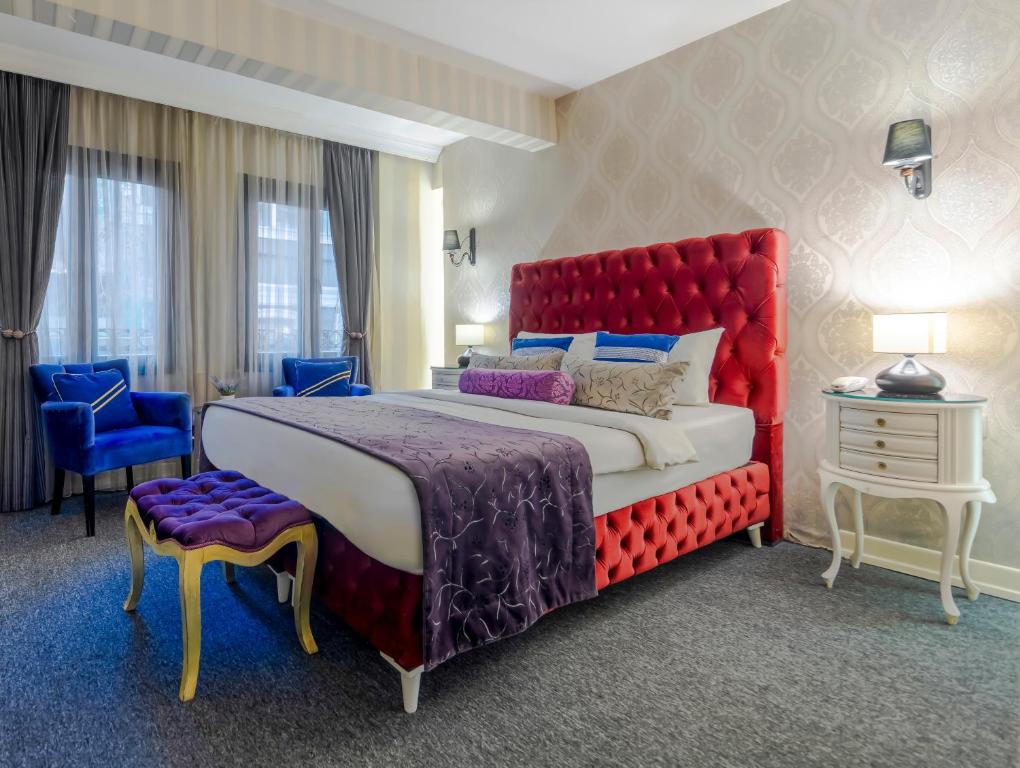 伊斯坦布尔In Pera Boutique Hotel的一间卧室配有一张大床和红色床头板