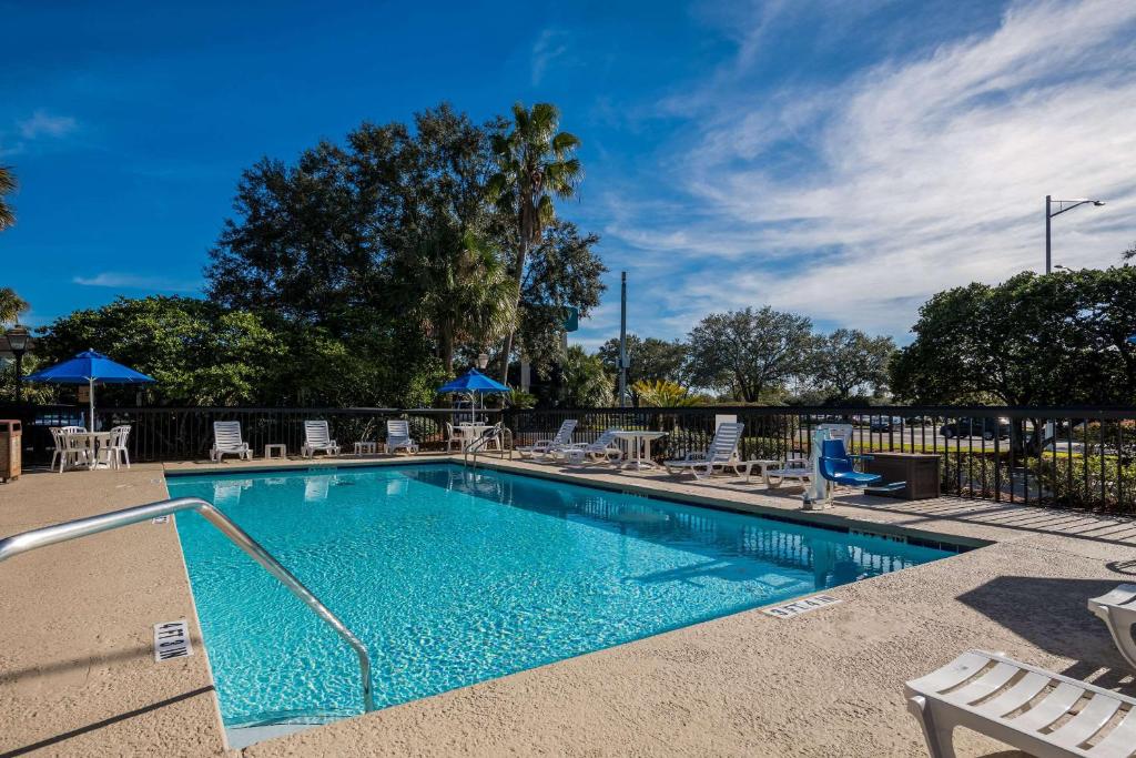 杰克逊维尔Quality Inn Orange Park Jacksonville的一个带桌椅的游泳池和围栏