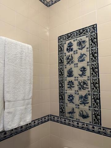 Monte CórdovaCasa dos três rapazes的浴室设有蓝色和白色图案的淋浴帘