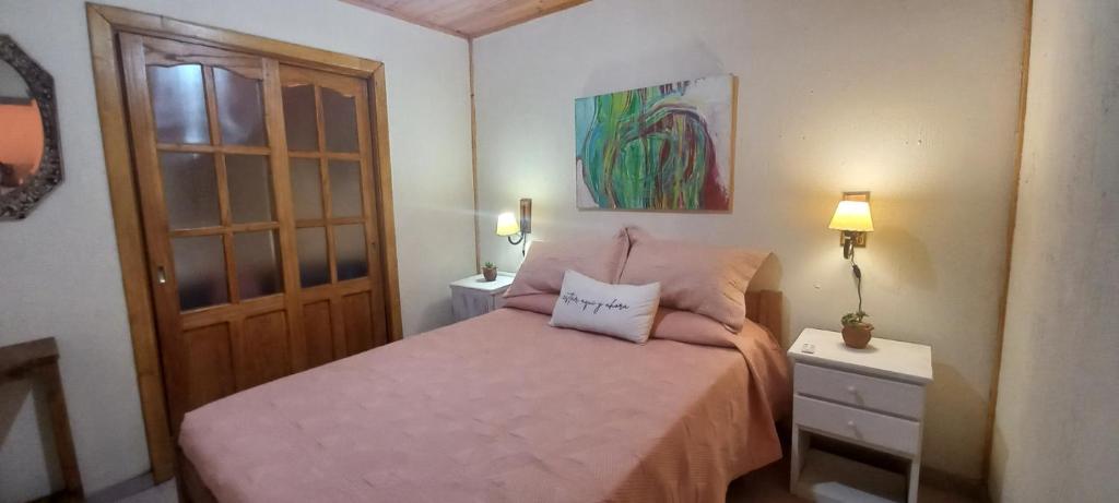 圣洛伦索Rincón de Afrodita的一间卧室配有一张带粉红色床罩的床