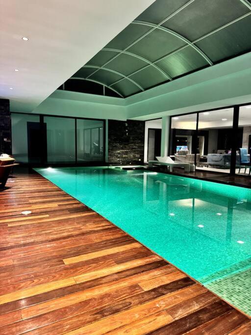 纳布勒Luxury villa with a heated indoor pool and direct access to the beach的一座铺有木地板的建筑中的大型游泳池