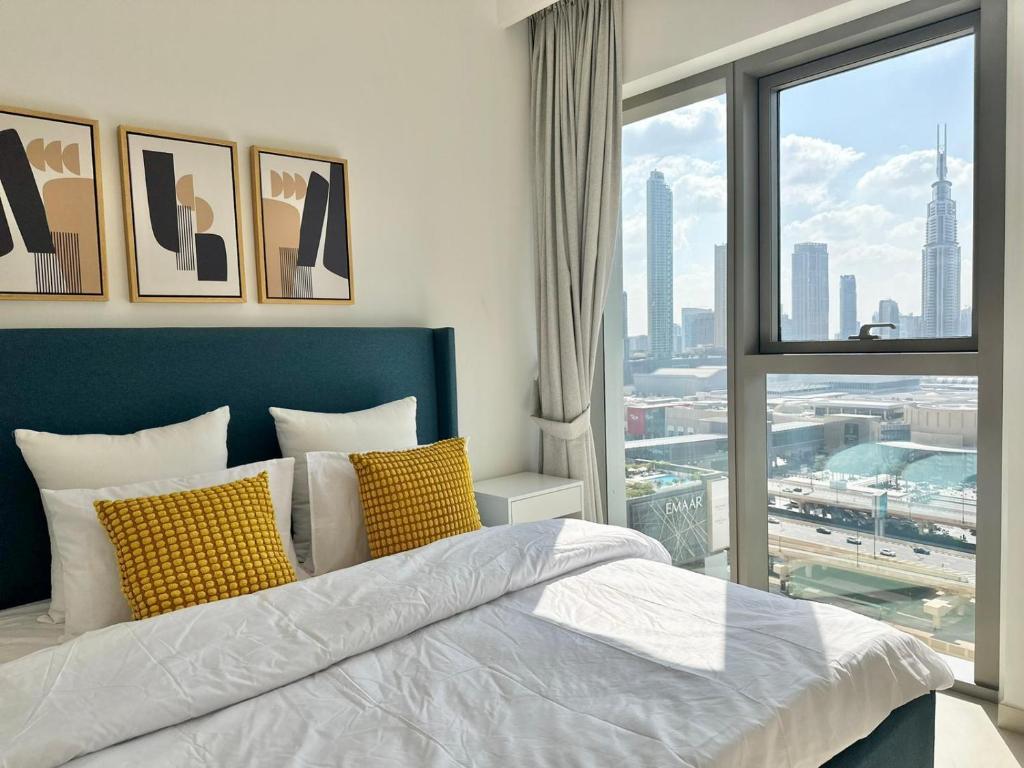 迪拜Luxury Apartment Downtown Dubai Mall Burj Khalifa View free Netflix & Prime Video的一间卧室设有一张床和一个大窗户