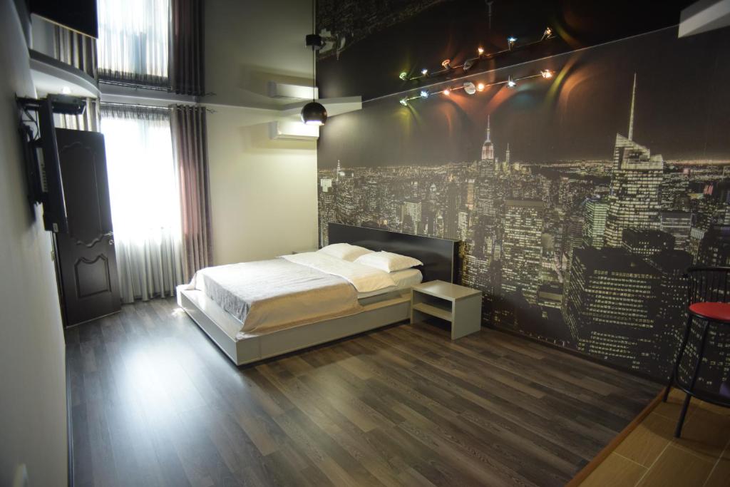 塔拉兹SEQUOIA boutique hotel的卧室配有一张床铺,位于带墙壁的房间