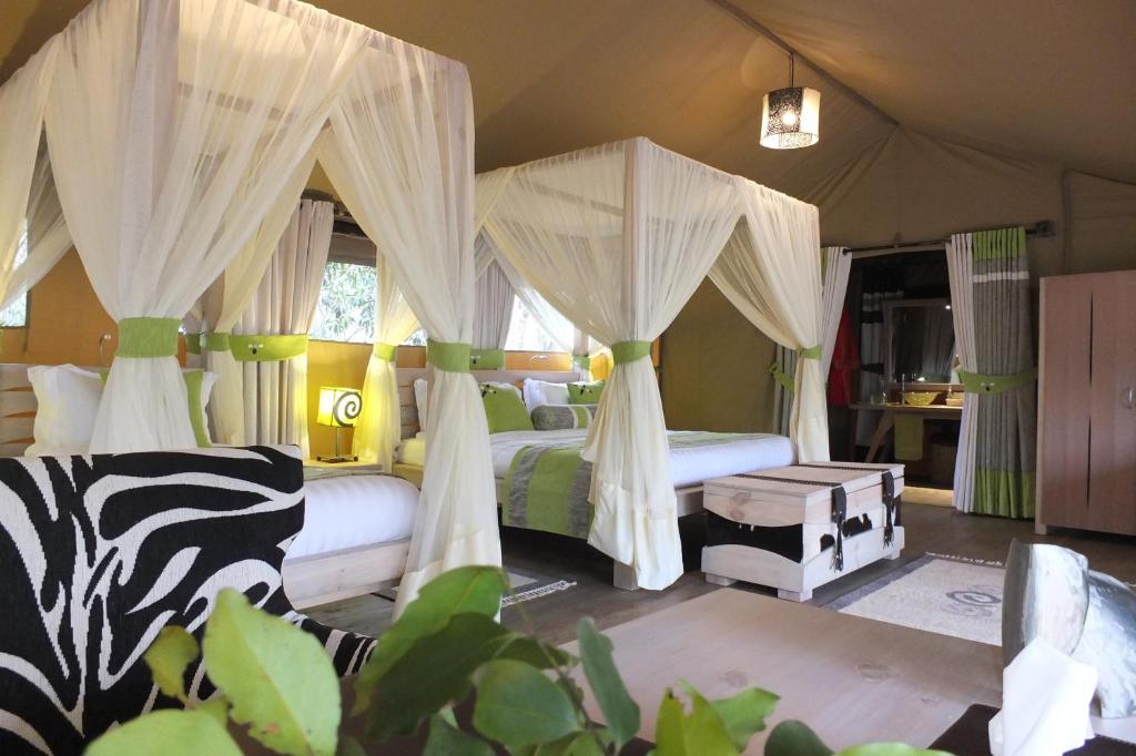 马赛马拉Soroi Private Wing的一间卧室配有两张带蚊帐的床