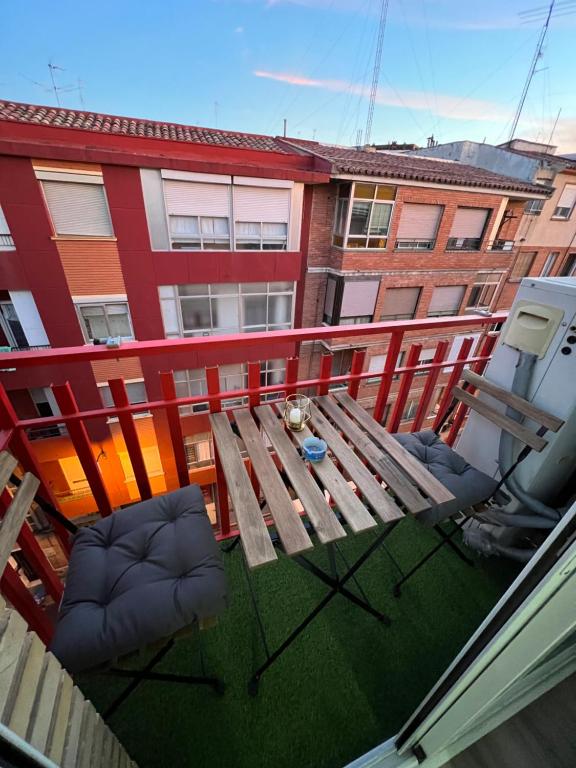 萨拉戈萨Apartamento en Zaragoza con parking的阳台享有木桌和椅子的顶部景致。