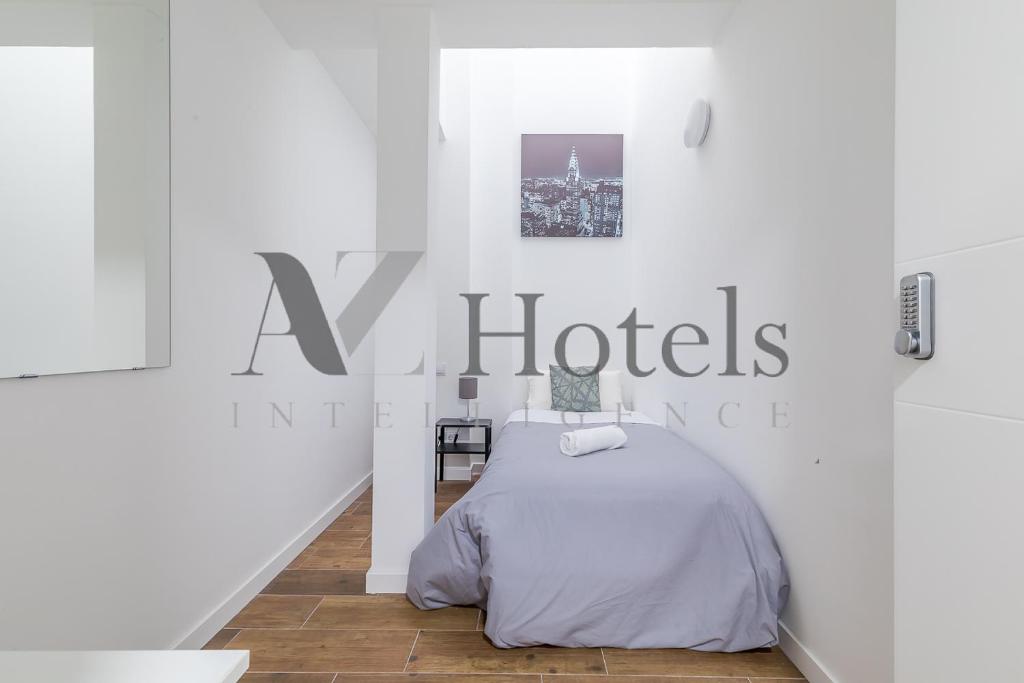 马德里AYZ Luis Cabrera-Auto check-in property的白色的房间,配有床和酒店标志