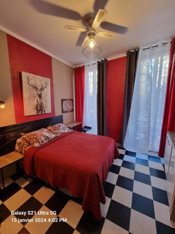 马赛Hôtel des allées的一间卧室设有一张红色的床和一张 ⁇ 格地板