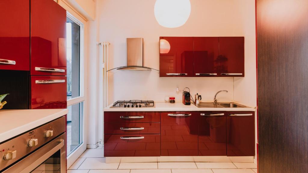 维罗纳Palazzo San Zeno的一间带红色橱柜和水槽的厨房