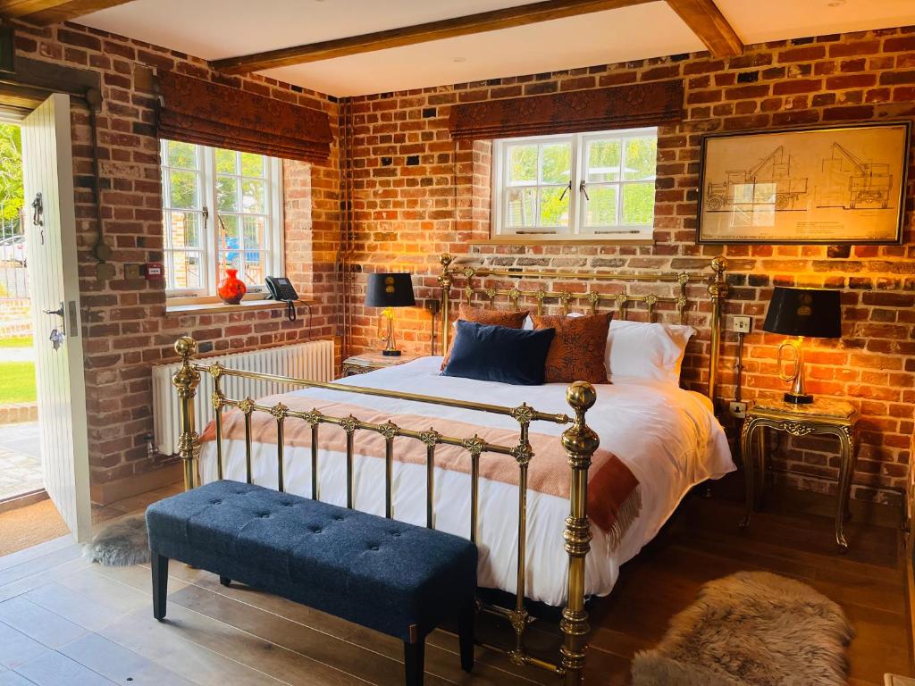 East BergholtThe Lion的一间卧室设有一张床和砖墙