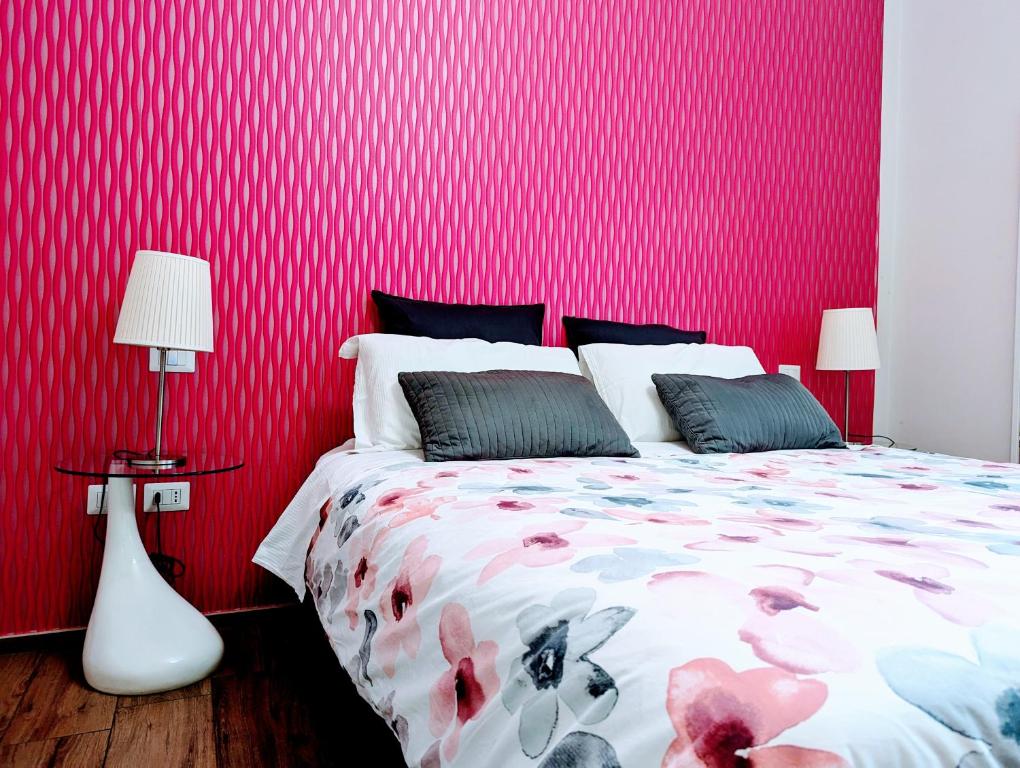 萨莱诺gia'Notte BB Salerno Centro by ElodeaGroup的一间卧室设有红色墙壁、一张床和两盏灯。
