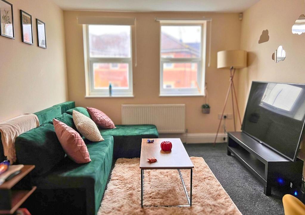 布里斯托Charming Flat in Central Bristol的客厅配有绿色沙发和桌子
