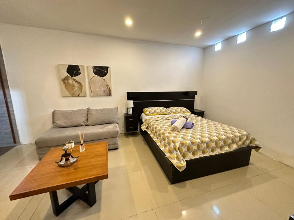瓜亚基尔Suite Bosque de la Alborada B的一间卧室配有一张床和一张茶几