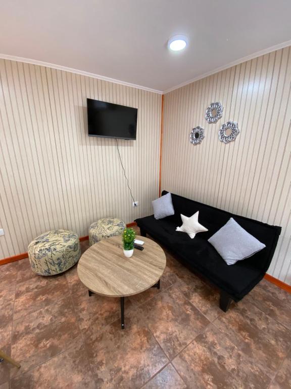 奥索尔诺Arriendo de cabaña centro osorno的客厅配有黑色沙发和桌子