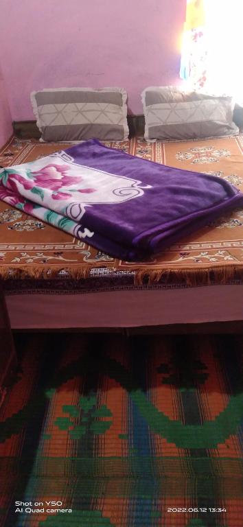 KibarSunflower in spiti kee的床上的紫色毯子