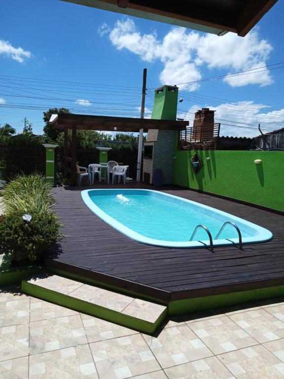 因贝Casa com piscina no imbé的房屋旁的木甲板上的游泳池